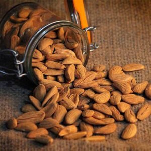 kashmiri mamra almonds overflowing jar